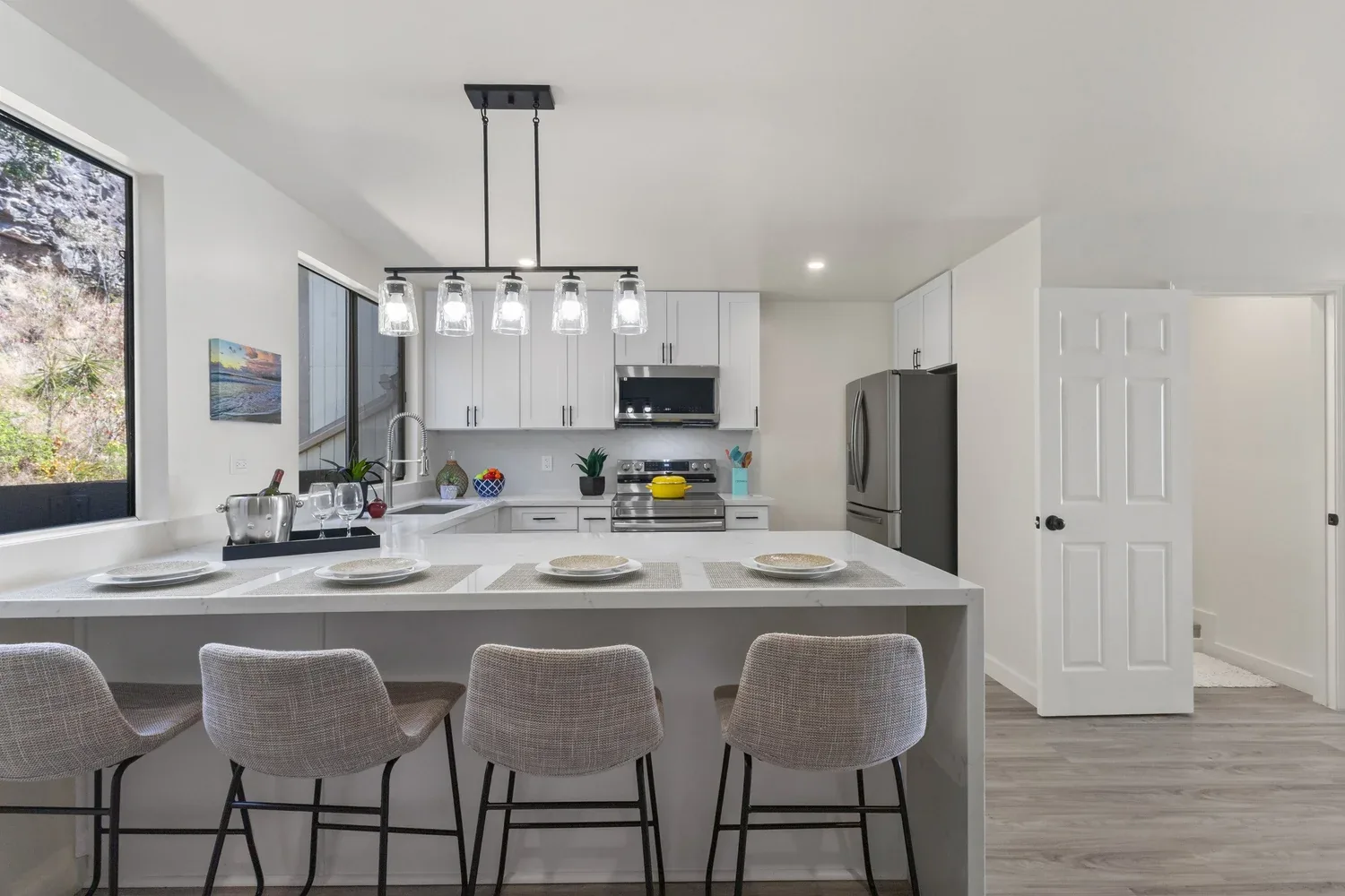 Renovated Oahu kitchen with island, white cabinets, and pendant lighting