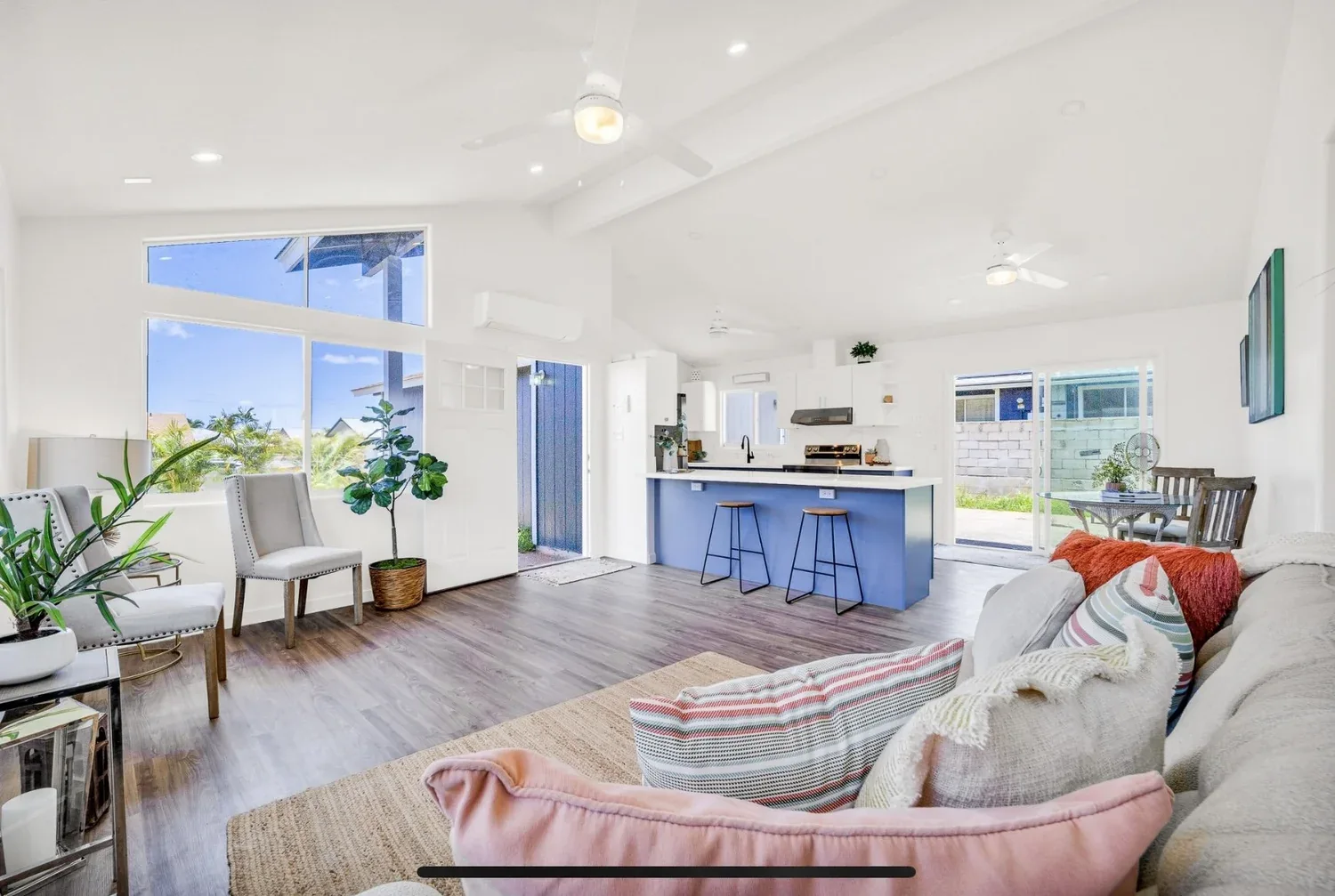 Renovated Oahu living room with blue kitchen island and open dining area